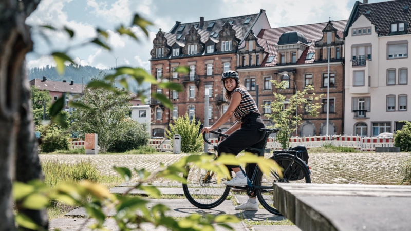 Eine Fahrradfahrerin auf dem Rad im Sommer in der Stadt