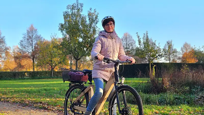 Bettina Hentschel mit ihrem nachhaltigen Holz-Fahrrad bei sonnigem Herbstwetter auf einem Weg