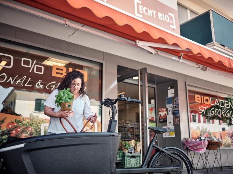 Jobradlerin verstaut ihren Einkauf im Lastenrad