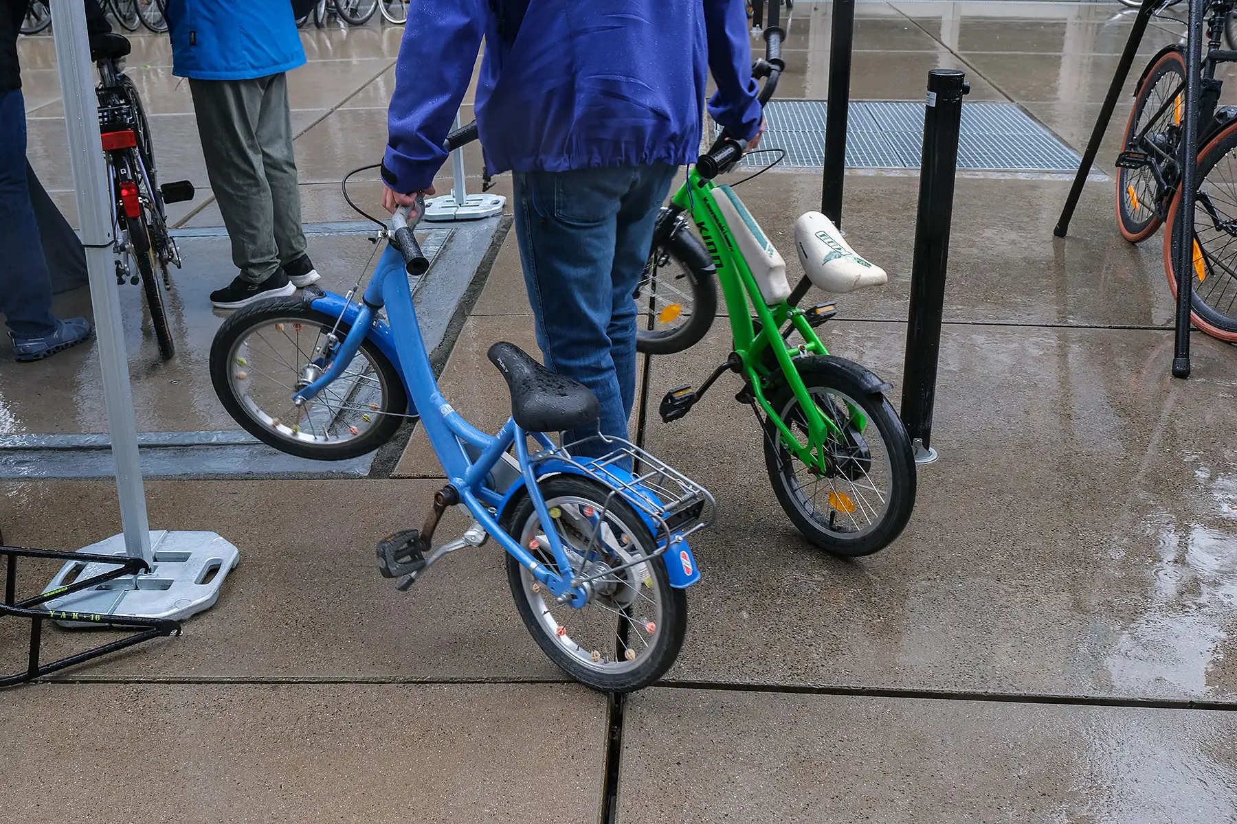 zwei gespendete Kinderfahrräder werden weggetragen zwei gespendete Kinderfahrräder werden weggetragen
