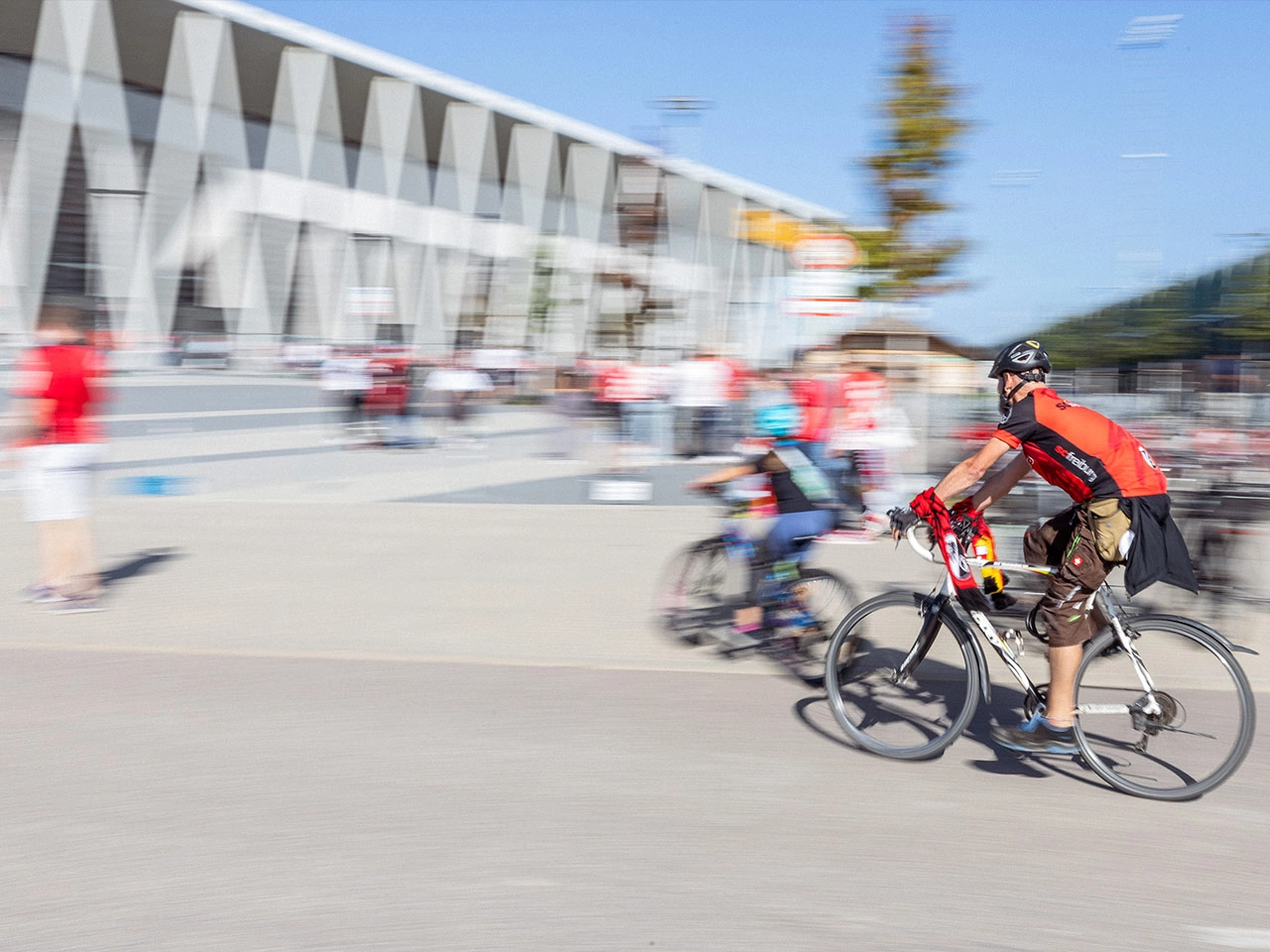 SC Fans in Trikots und Schal fahren mit dem Rad zum Europa-Park Stadion, mit Bewegungsunschärfe